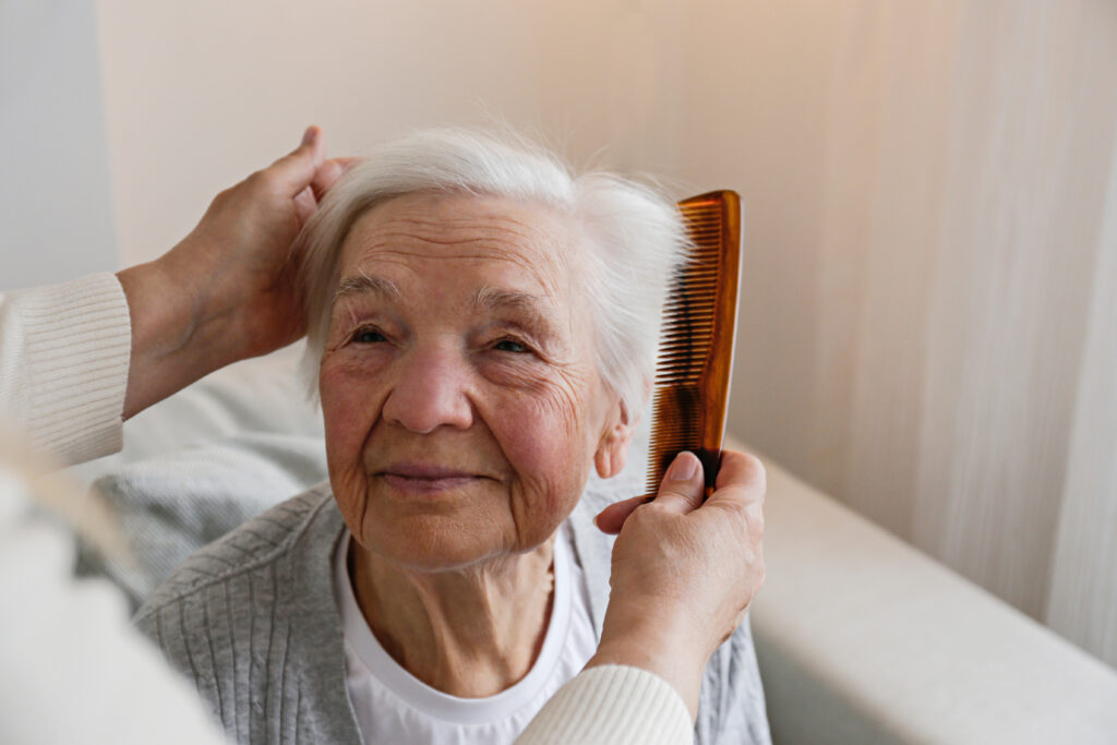 elderly women struggling at home to brush her hair