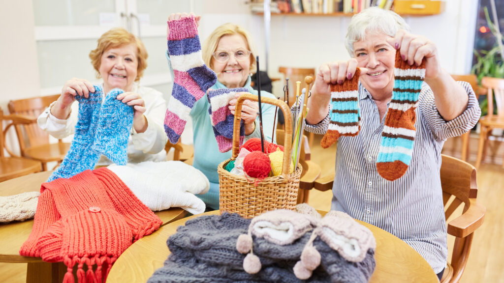 Seniors holding knitted socks, improve quality of life 