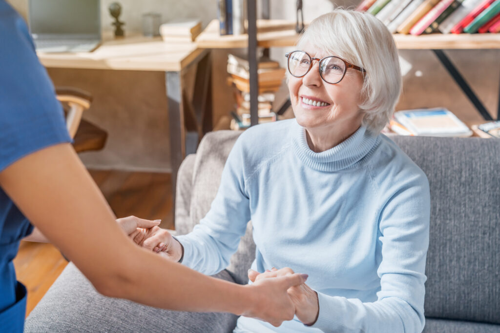 Caregiver helping elderly women in assisted living community