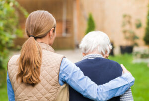 Adult daughter supporting an older woman outdoors while discussing illnesses that mimic dementia in seniors