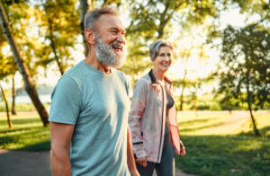 Older adults enjoying outdoor summer activities for seniors during a walk through a park