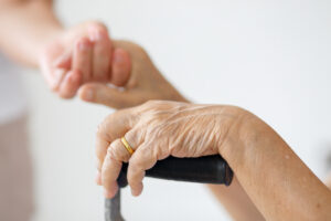 Caregiver assisting a resident, showing the difference between assisted living and memory care support.